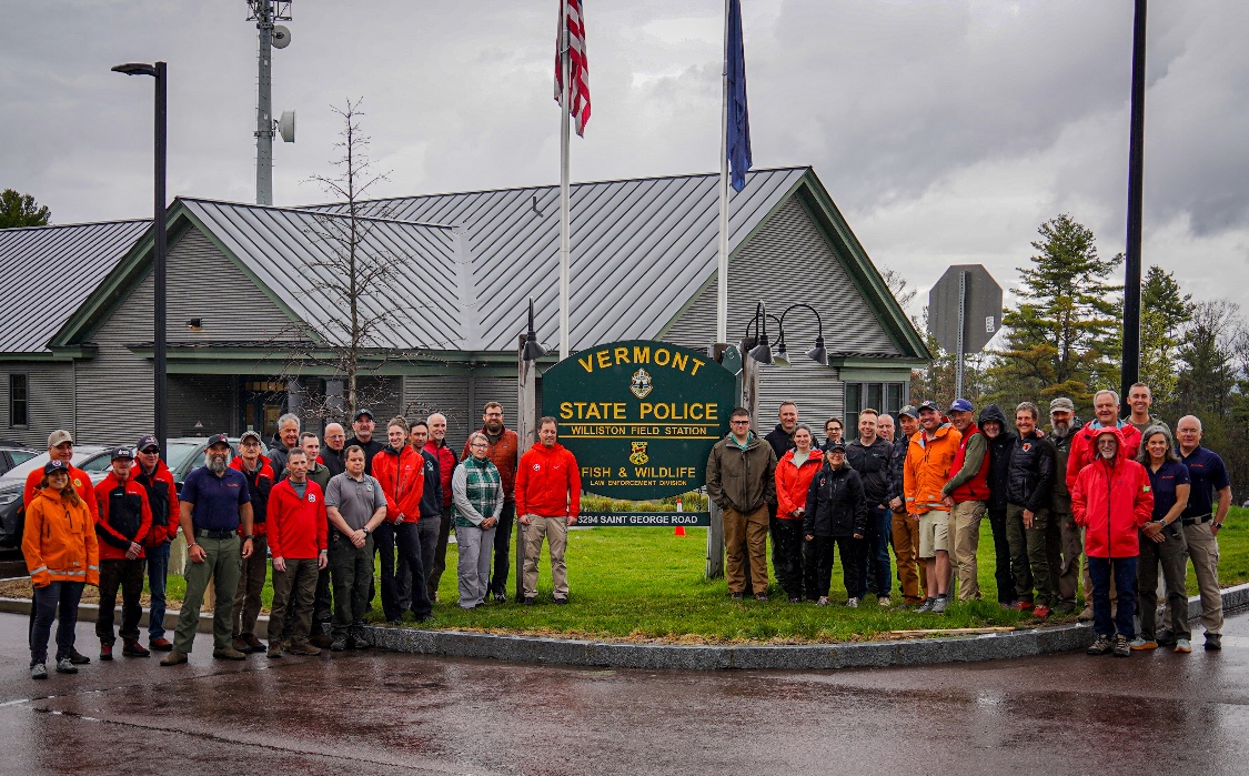 Course participants, including KSAR team leaders, gather for a group photo in front of the Vermont State Police Williston Field Station sign after the Managing the Lost Person Incident course